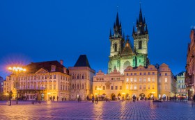 Tyn Cathedral and Old City Square in Prague illuminated at night.